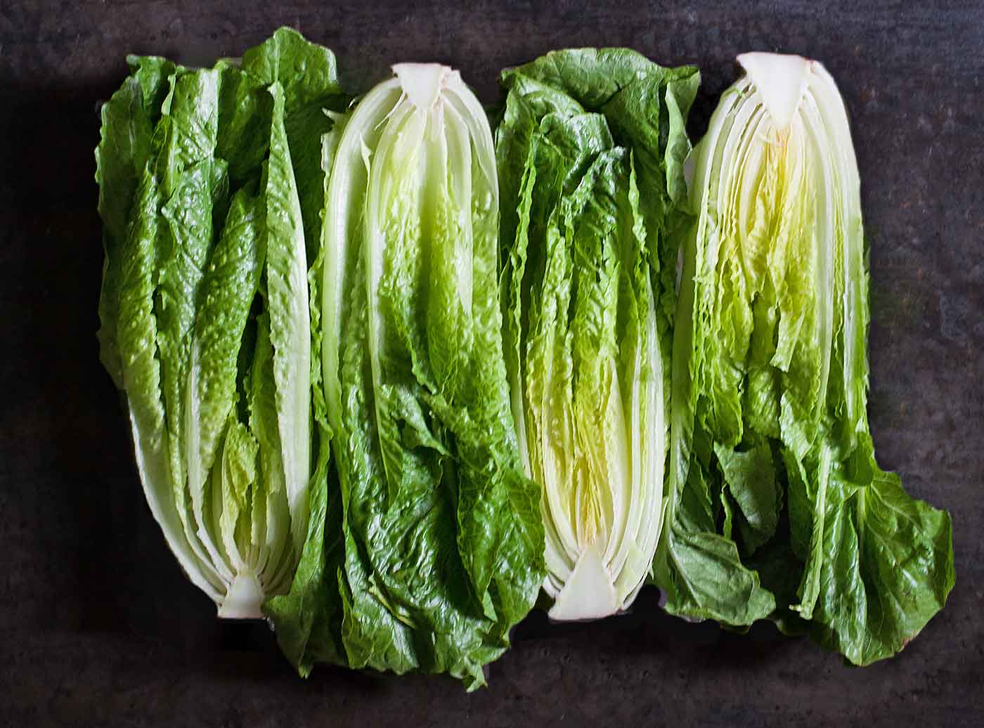 Romaine Lettuce halves on a dark background