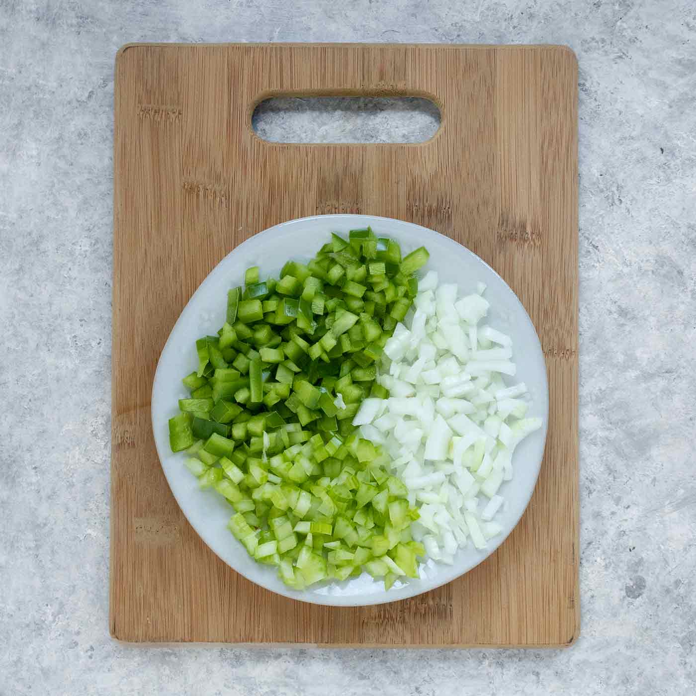 Chopped vegetables known as the Cajun Holy Trinity on a plate.