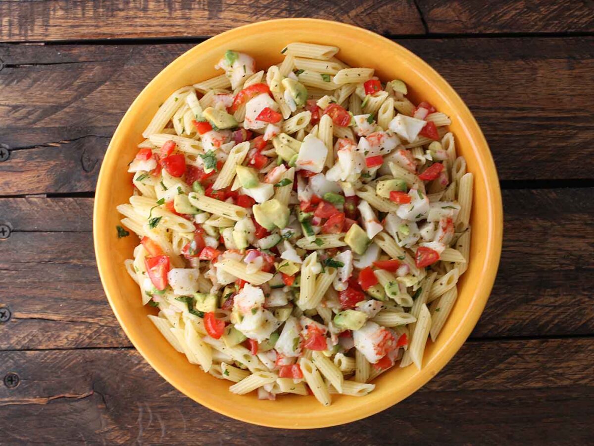 Overhead view of Avocado Crab Pasta Salad in a yellow bowl.