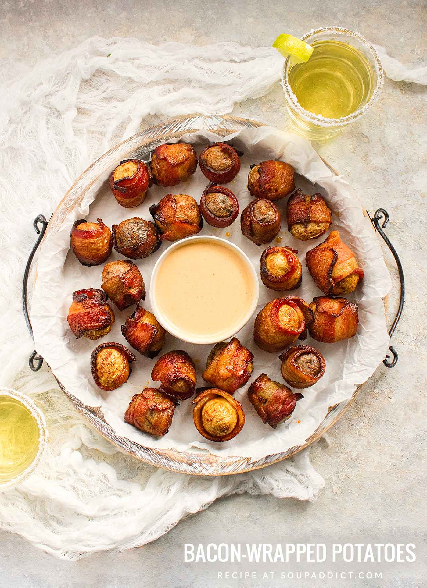 Bacon wrapped potato appetizers on a white serving platter