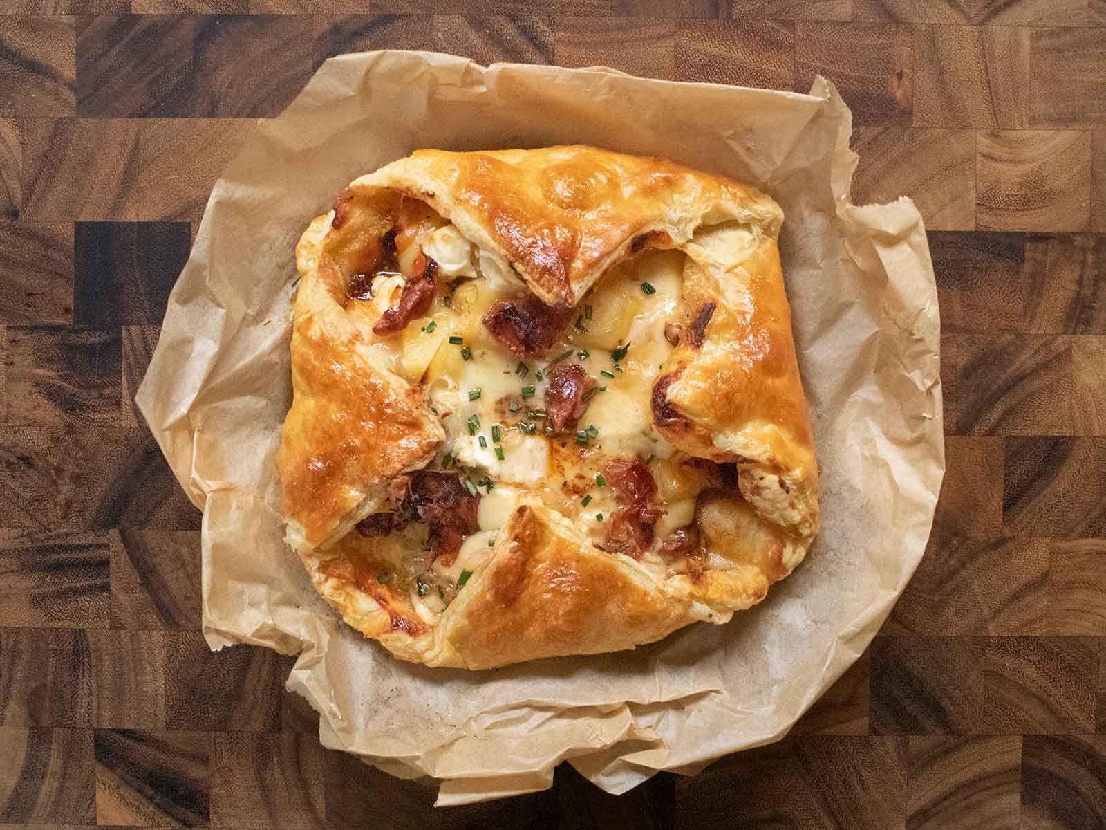 Overhead view of Baked Cheesy Puff Pastry with Crispy Prosciutto on parchment paper.