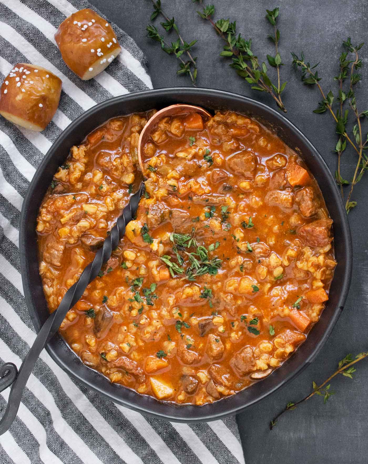 Close up view of Beef Barley Soup in a black bowl.