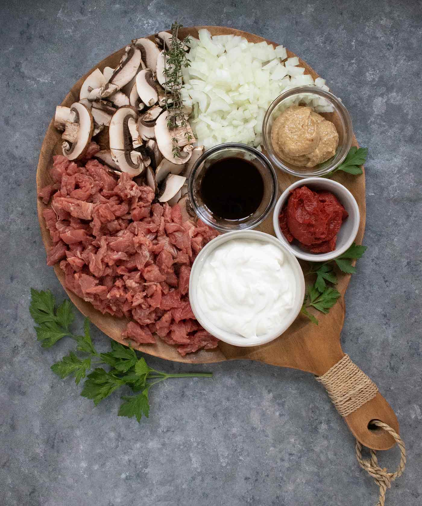 Ingredients for Beef Stroganoff Soup arranged on a wooden cutting board.