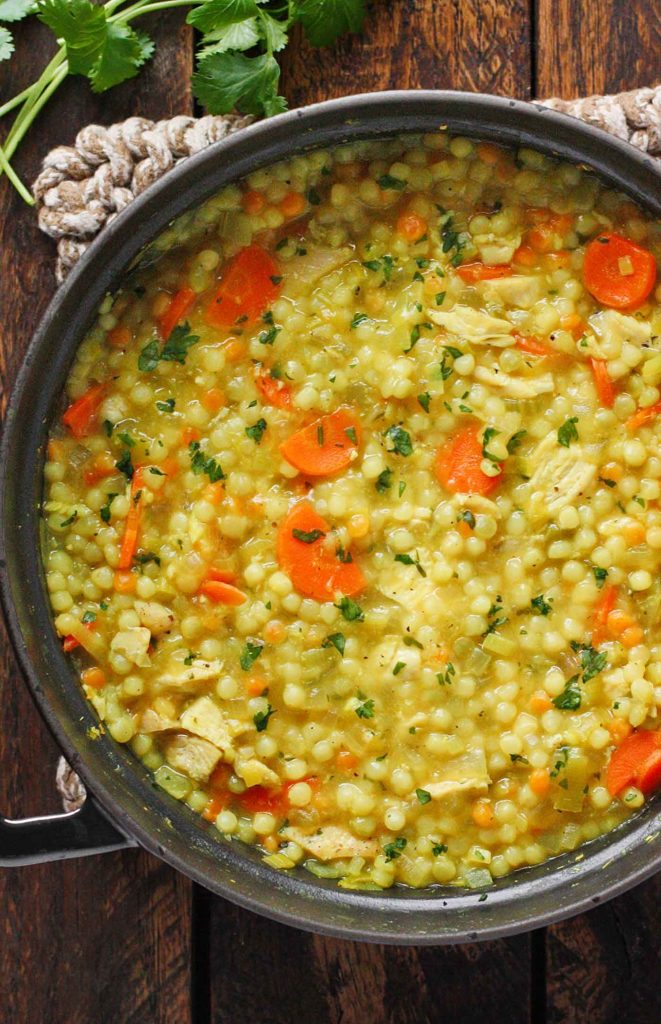 A black Dutch oven with Cold-Fighting Chicken Couscous Soup.