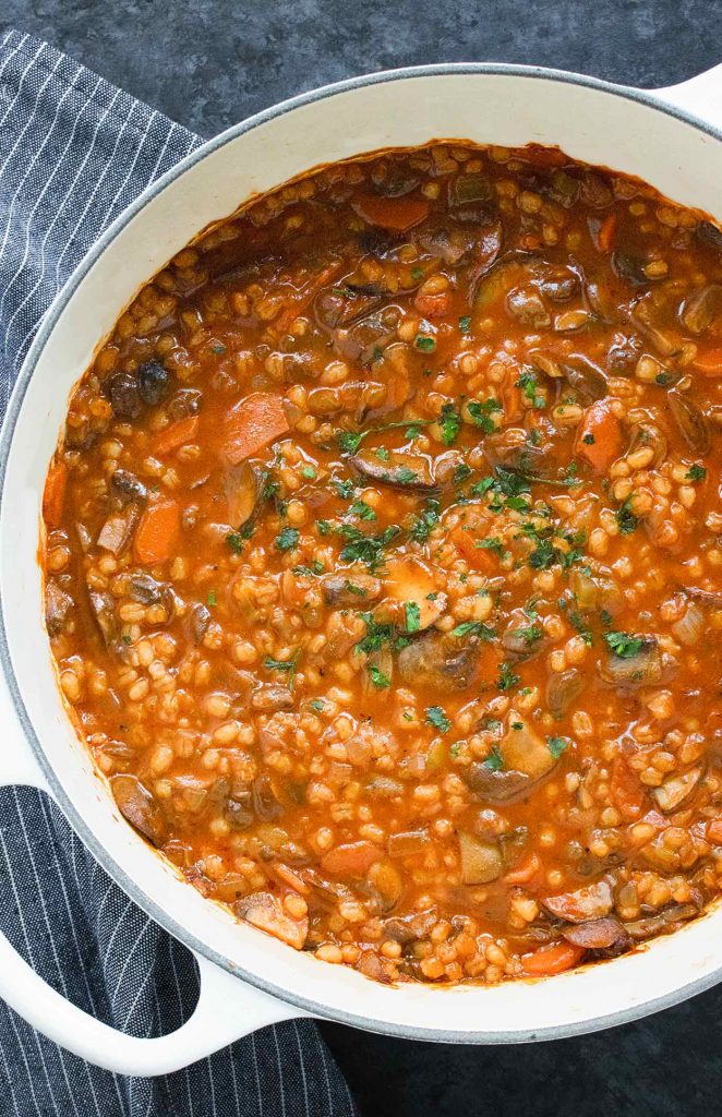A white Dutch oven with Mushroom Barley Soup.