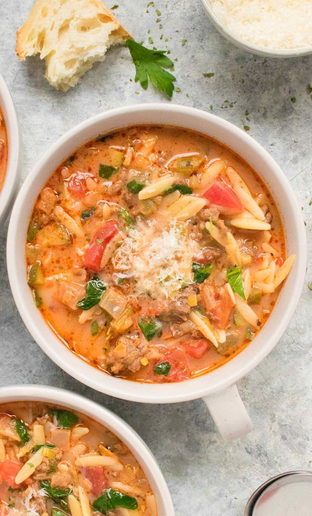 A light grey mug of Italian Sausage Orzo Soup.