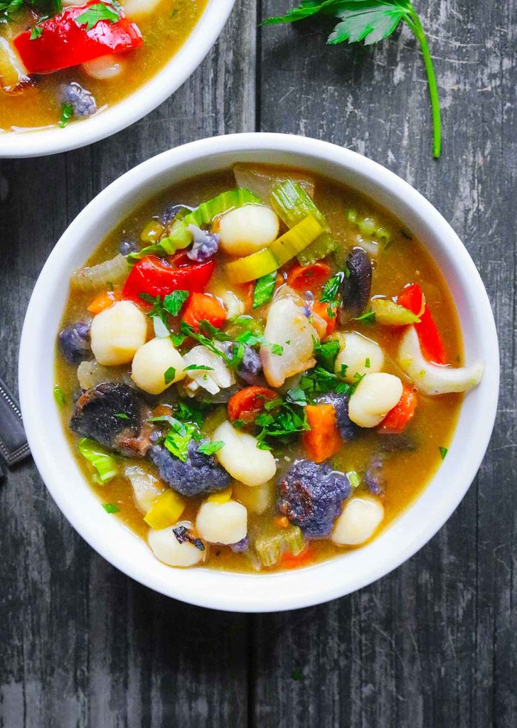 A white soup bowl filled with Roasted Sheet Pan Vegetable Soup.