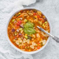 A bowl of Bowtie Vegetable Pasta topped with a spoonful of pesto