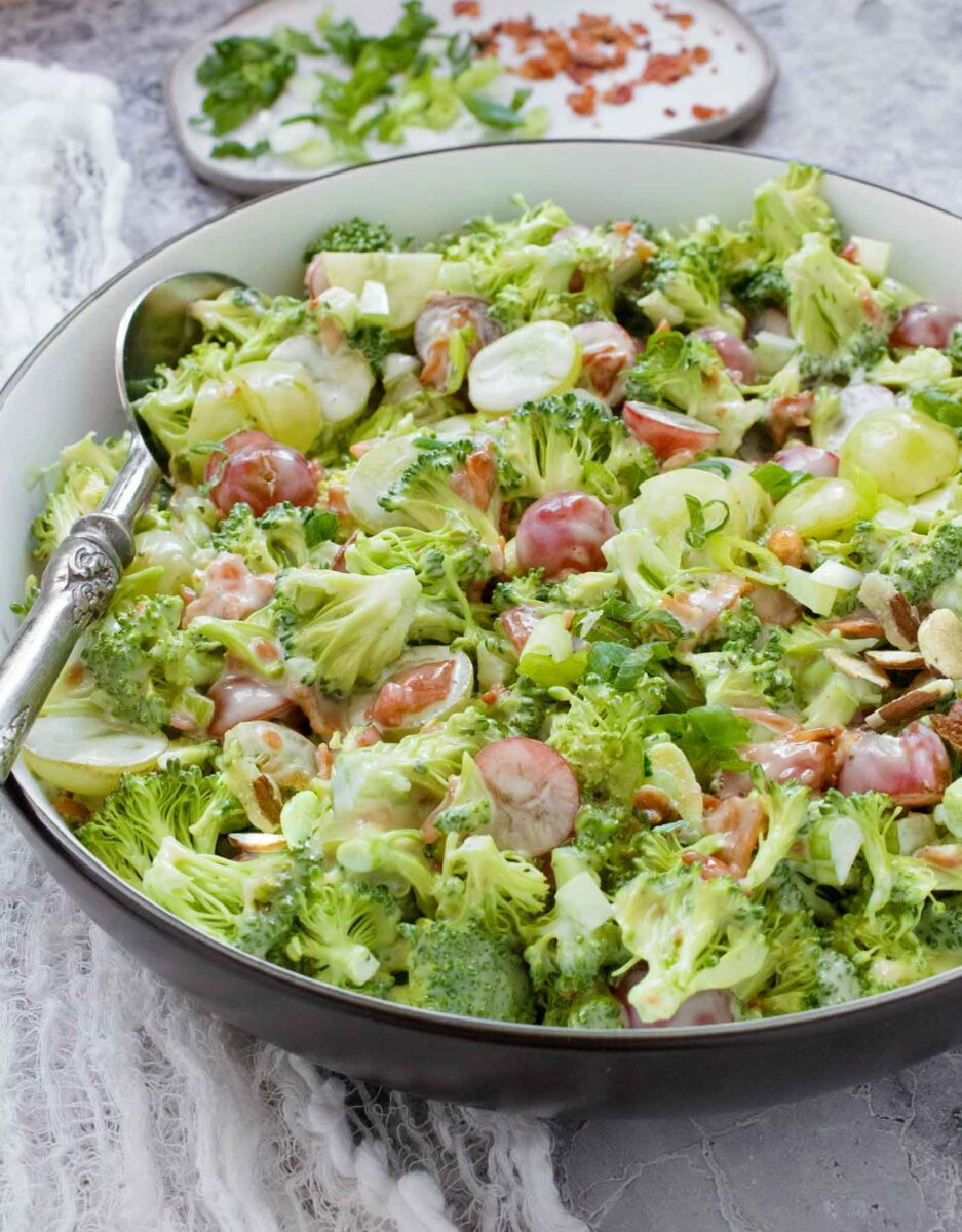 Side angled view of Broccoli Grape Salad in a white bowl.