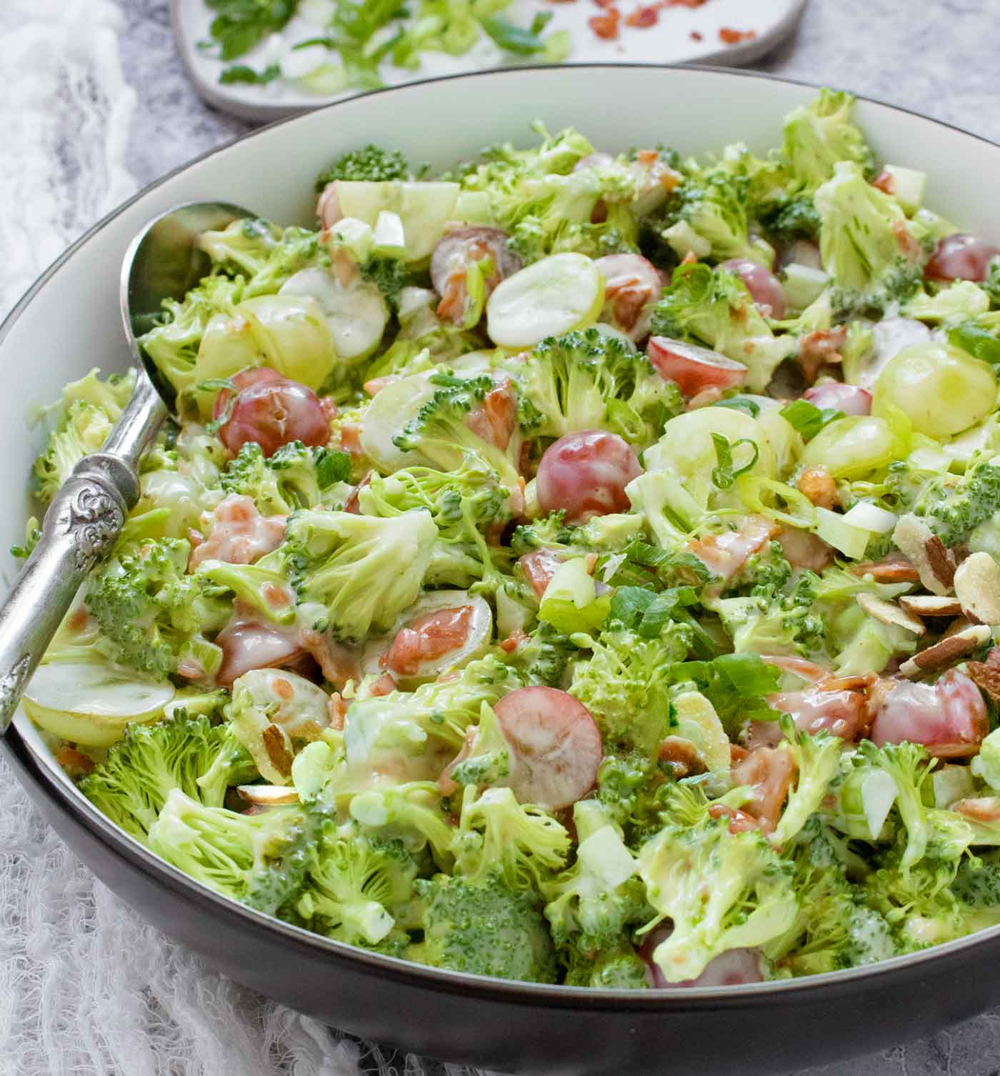 Side-angled view of Broccoli Grape Salad in a bowl with a spoon.