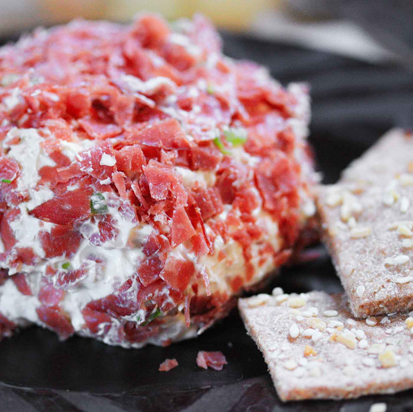 Dried Beef Cheese Ball with crackers on a serving plate.
