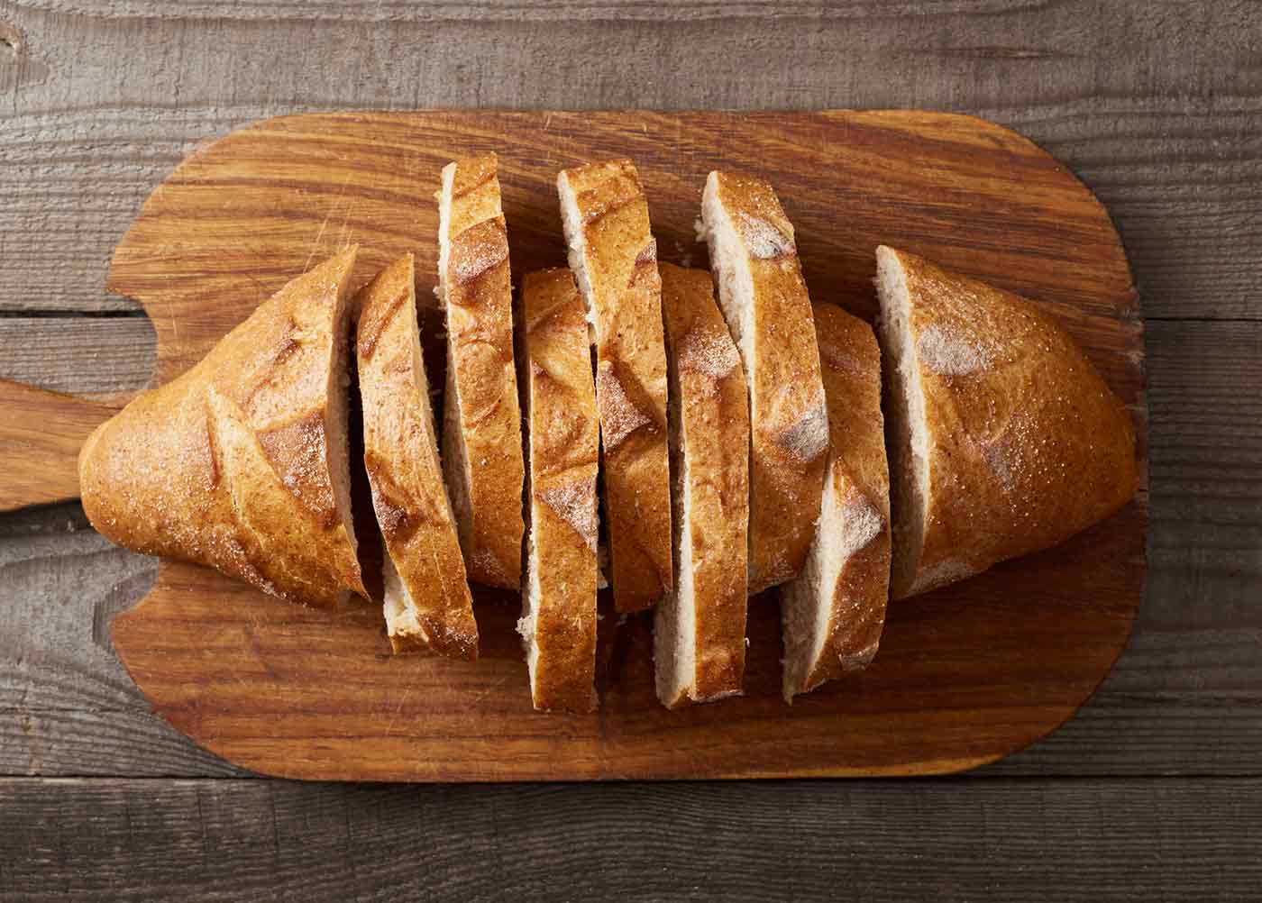 A sliced sourdough loaf on a bread board.