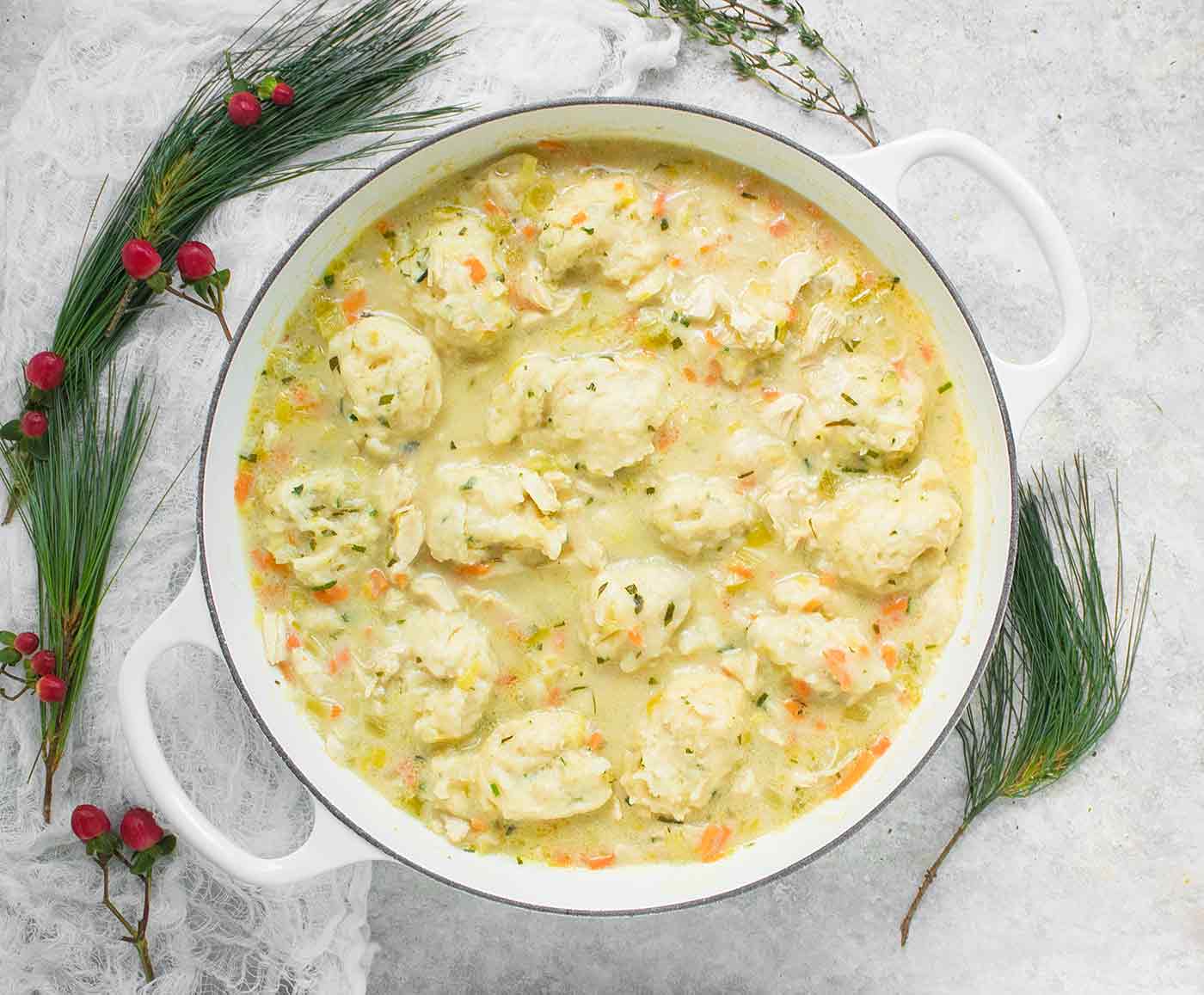 White Dutch oven filled with Chicken and Dumplings