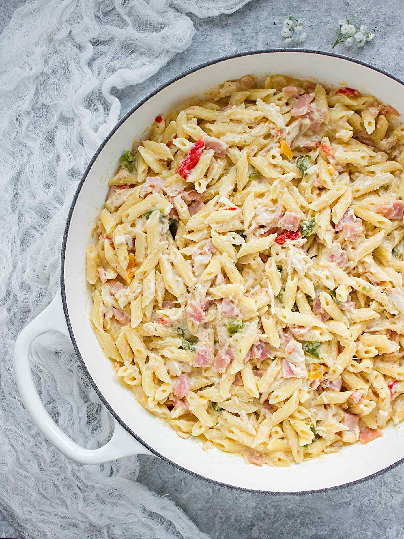 White dutch oven filled with Chicken Cordon Bleu Pasta, ready to serve