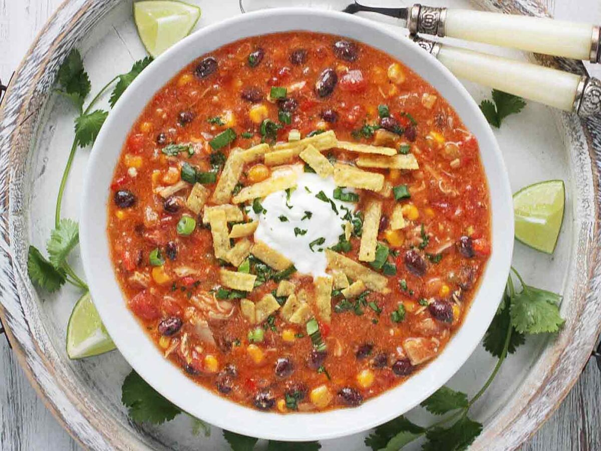 Overhead and close-up view of a bowl of Chicken Enchilada Soup.