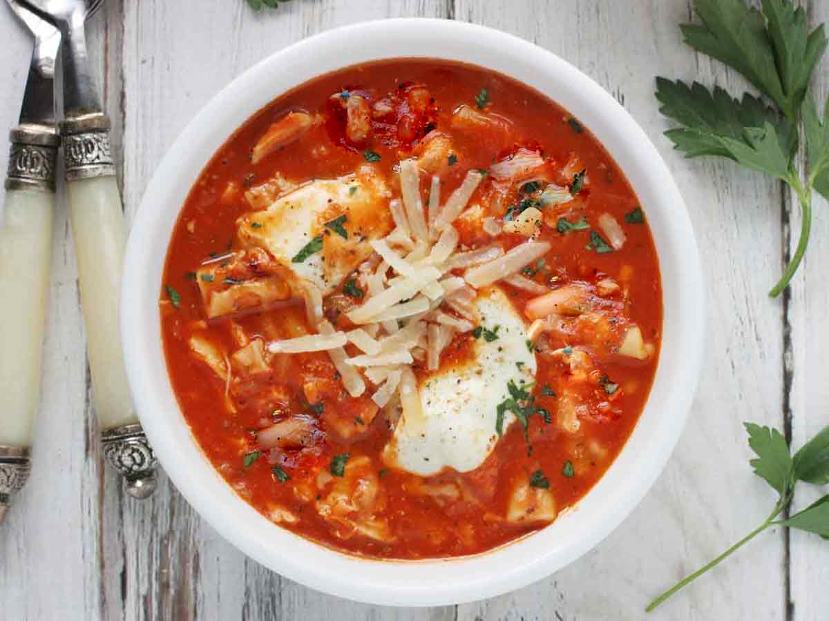 Overhead shot of Chicken Parmesan Soup in a white bowl.