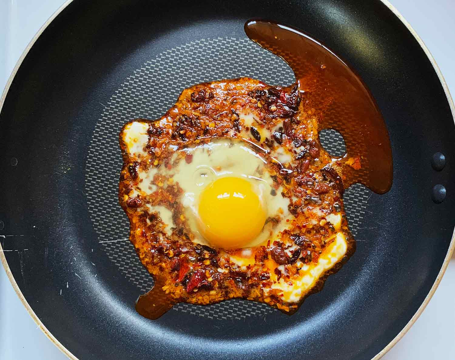 Crack an egg into the chili crisp and let cook. 