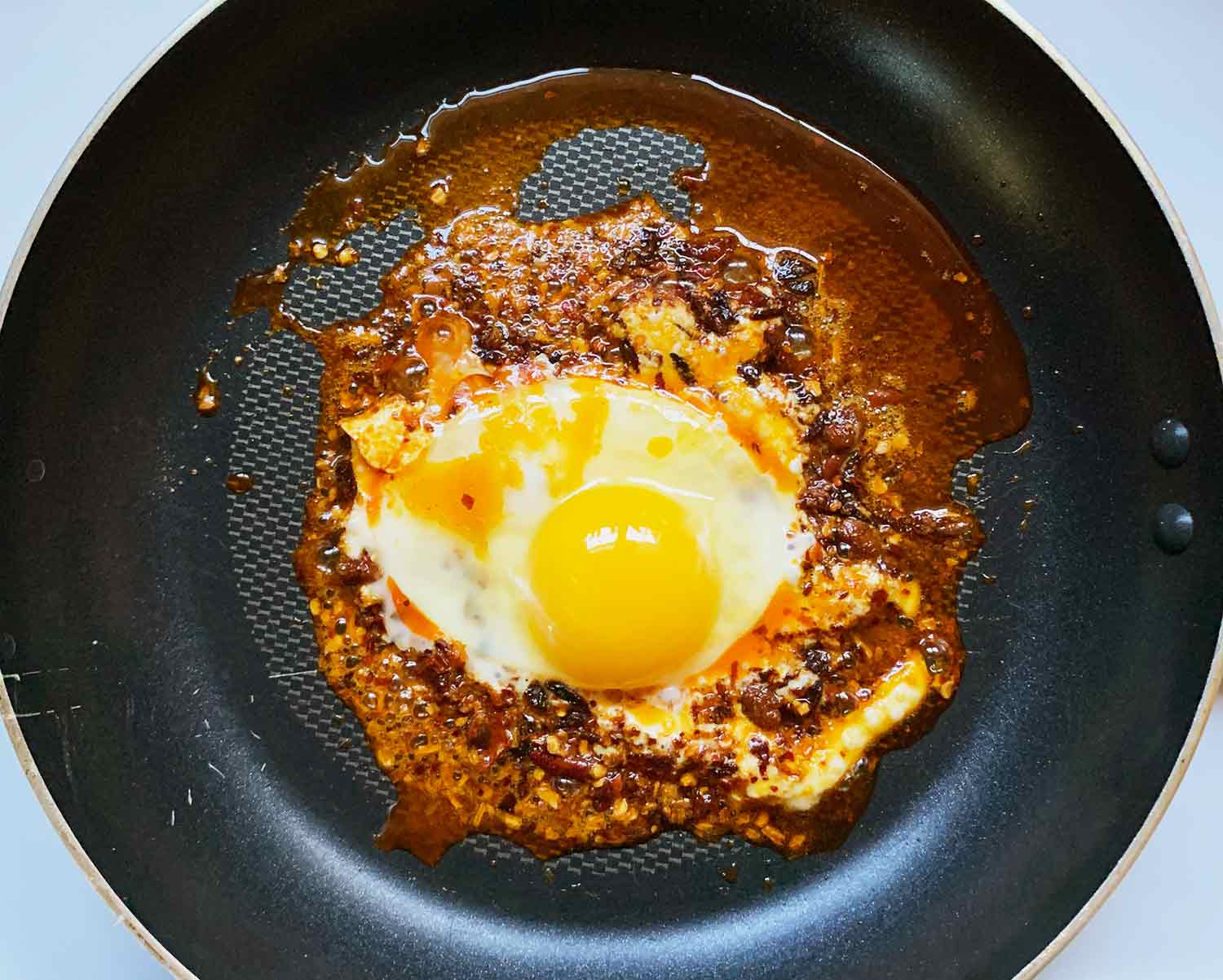 Cook the fried egg so that the whites are firm and yolk is to your desired doneness, soft or firm. Spoon pooled oil over the egg as it cooks for extra flavor.