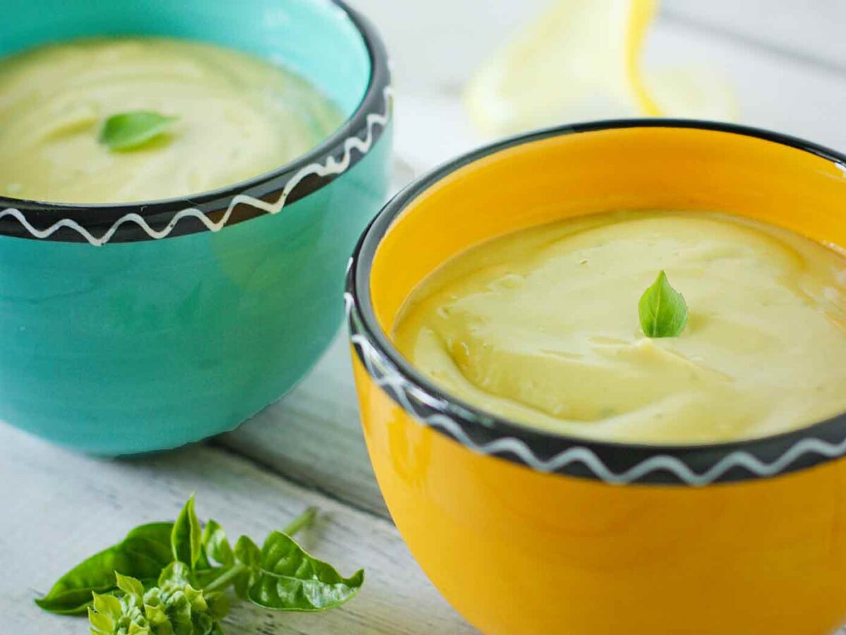 Side-angled view of two bowls of Chilled Avocado Soup.