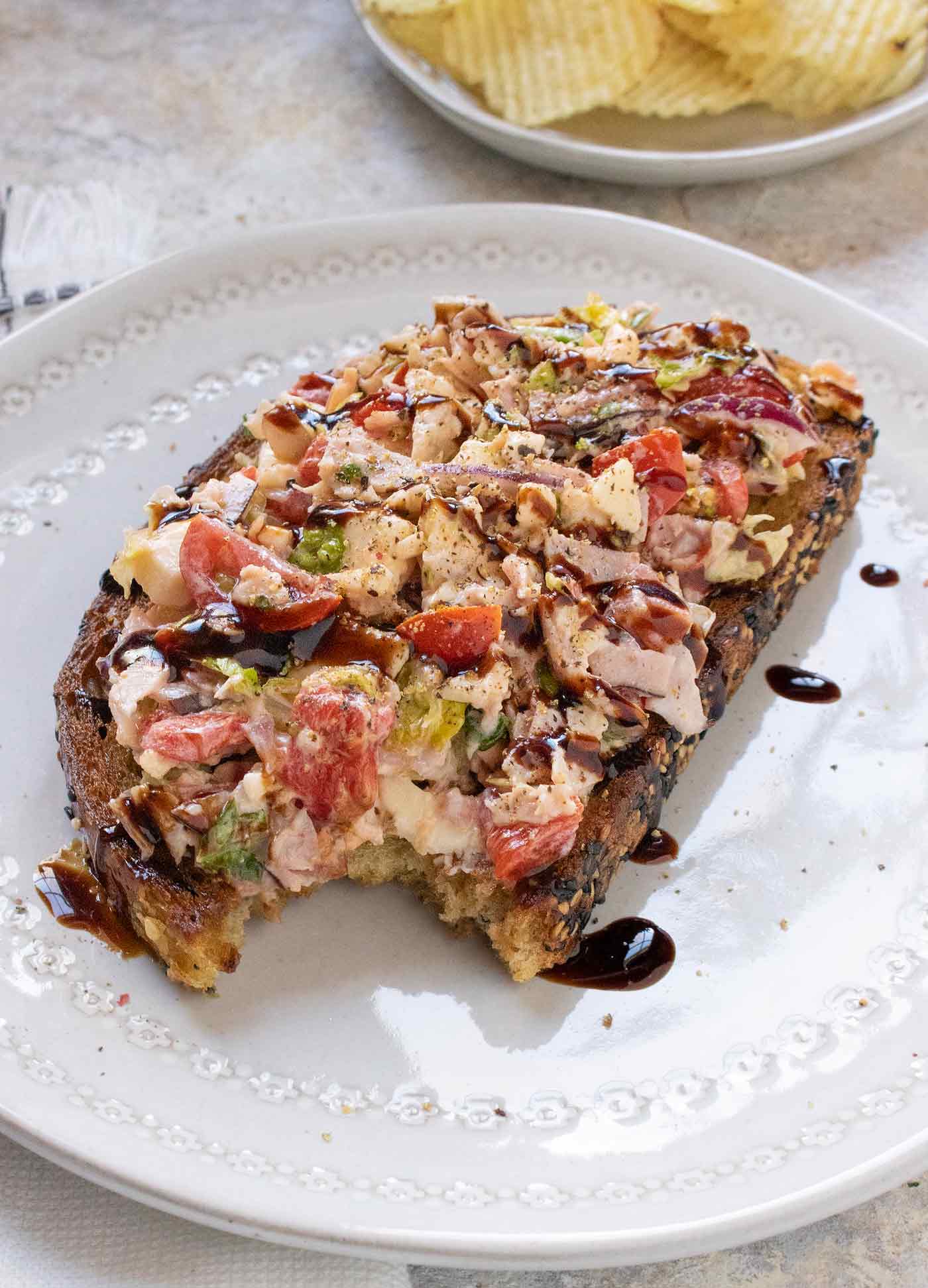 Angled view of the fried toast with a bite taken out of it, showing the layers of ingredients.