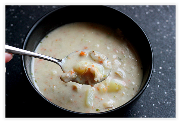 A close-up of a spoonful of New England Clam Chowder