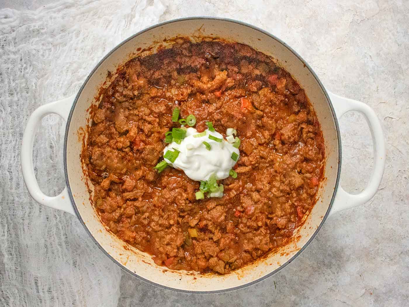 Overhead view of Classic Beef Chili in a large white Dutch oven.