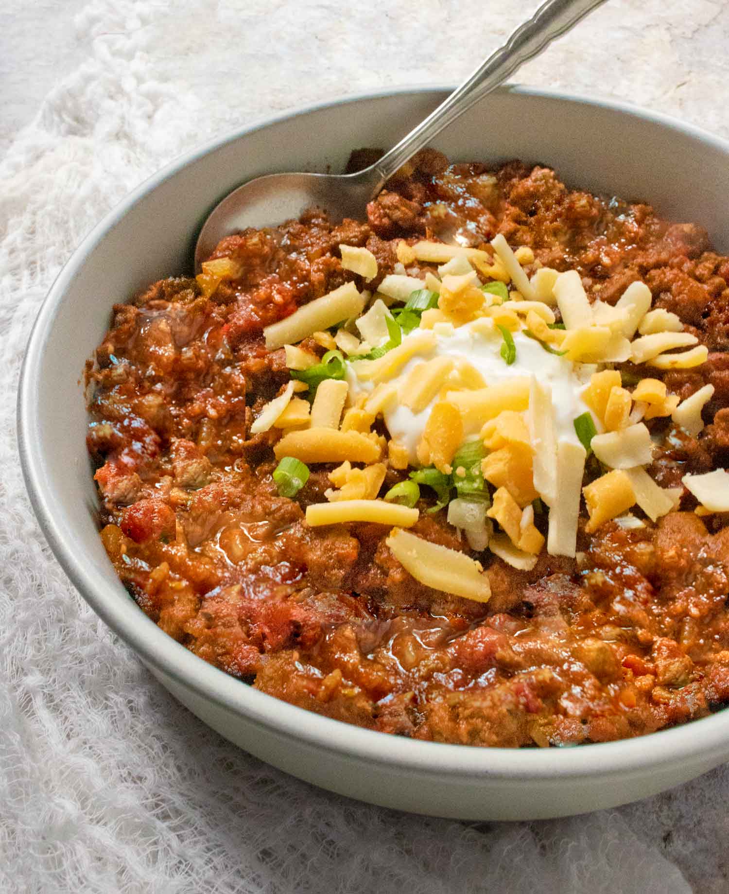 Angled view of Classic Beef Chili in a bowl with a spoon.