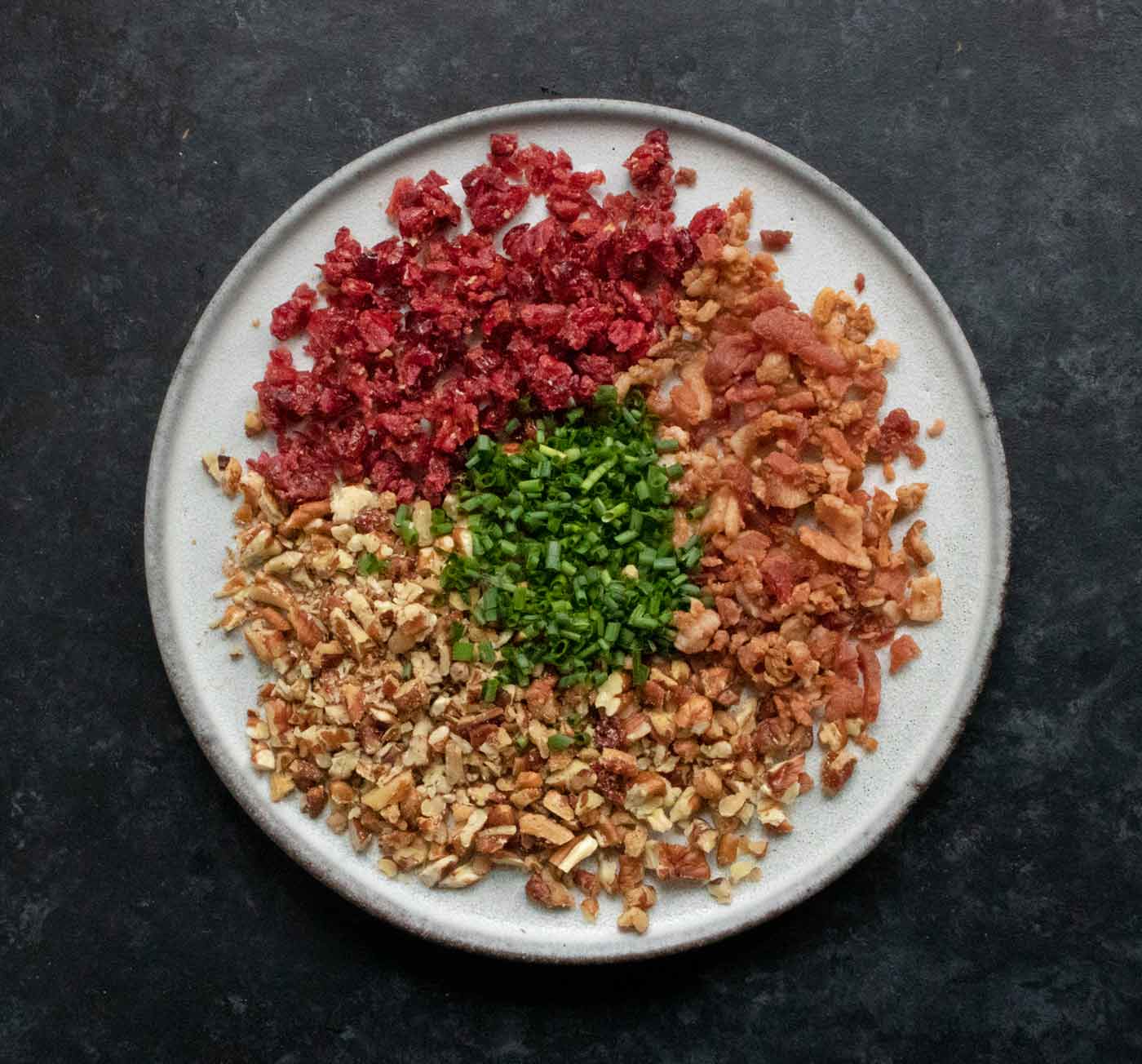 Ingredients for the cheese log topping spread out on a plate.