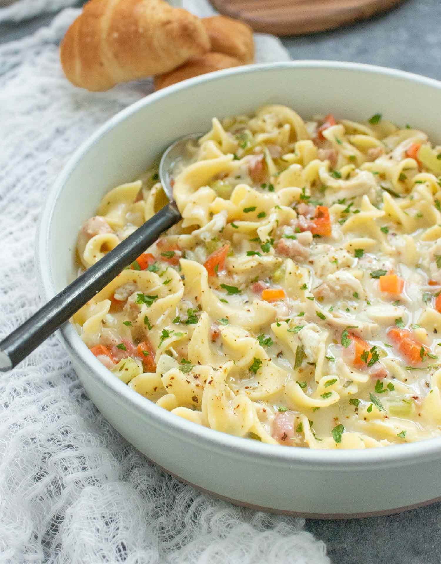 Angled view of a bowl of Creamy Chicken Noodle Soup with Pancetta.