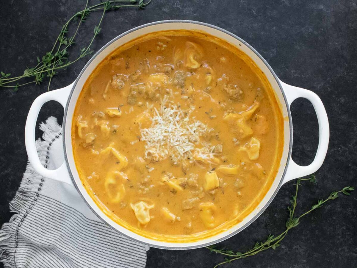 Creamy Pumpkin Sausage Tortellini Soup in a large white Dutch oven.