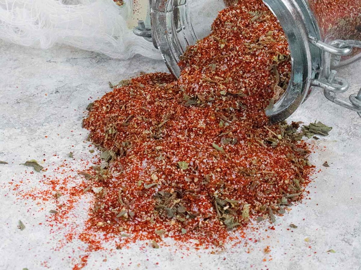 Creole Seasoning spices spilling out of a jar.