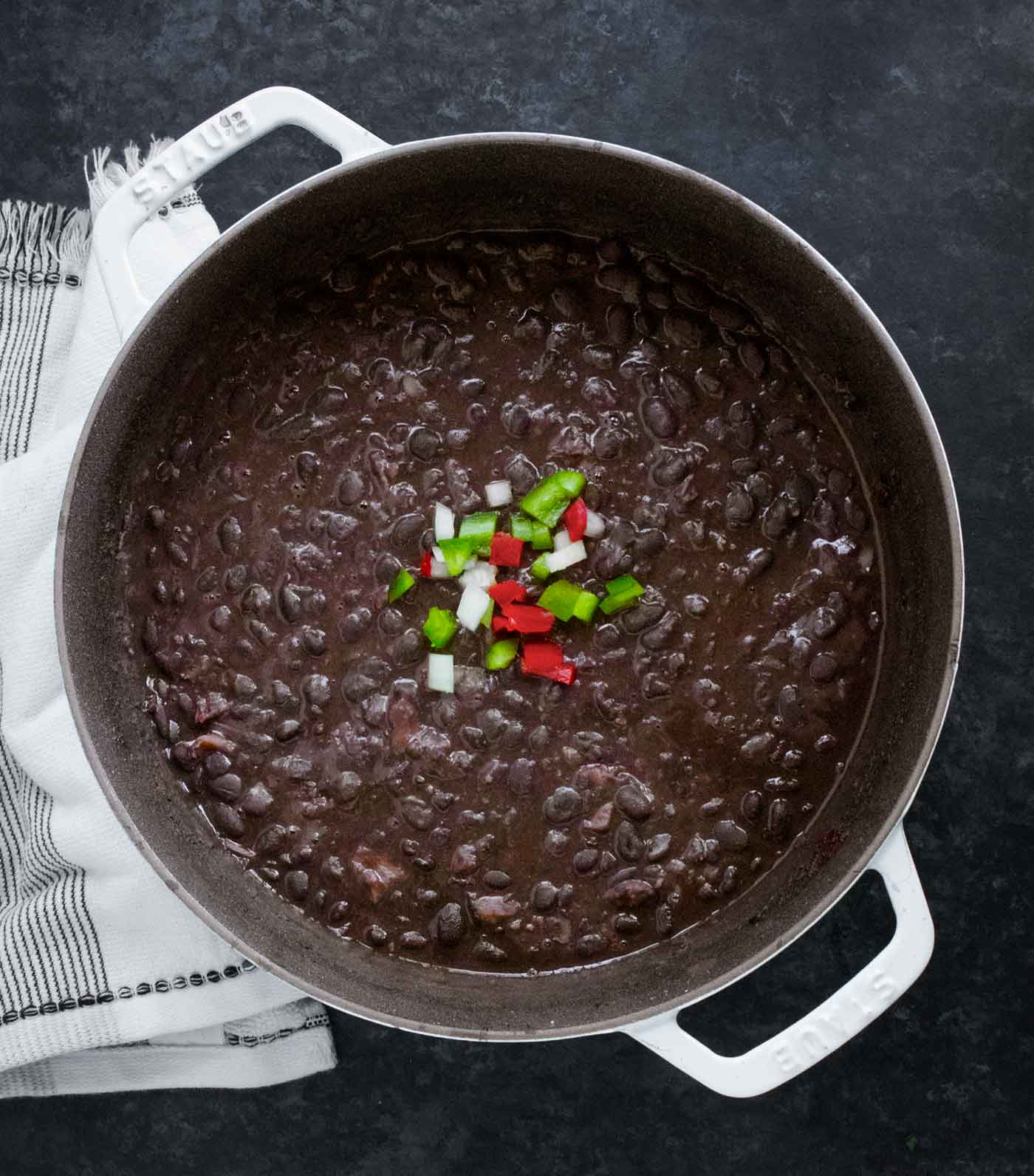 Overhead view of Cuban Black Bean Soup in a large white Dutch oven.