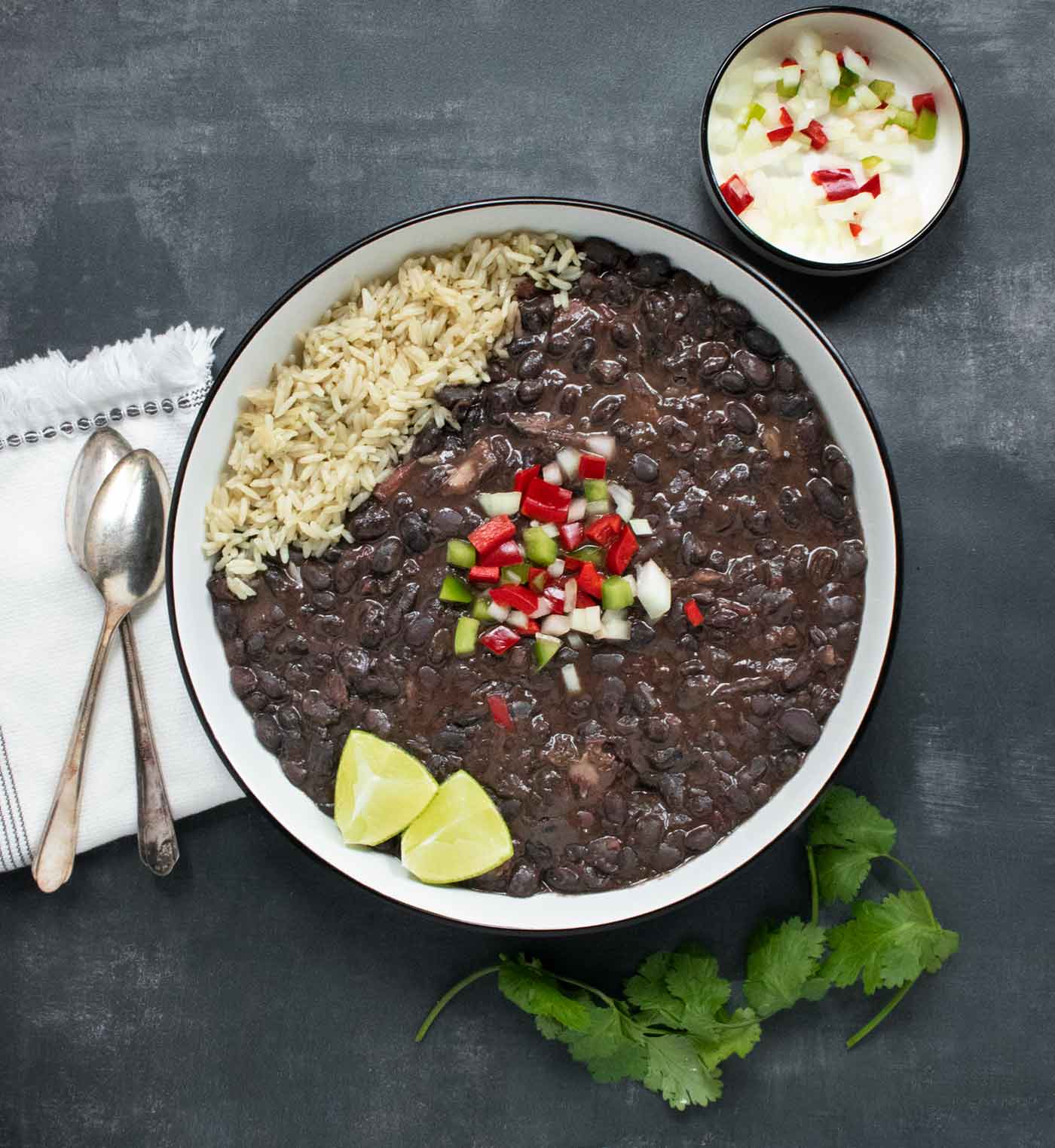 An overhead view of a bowl of Cuban Black Bean Soup with a side of rice.