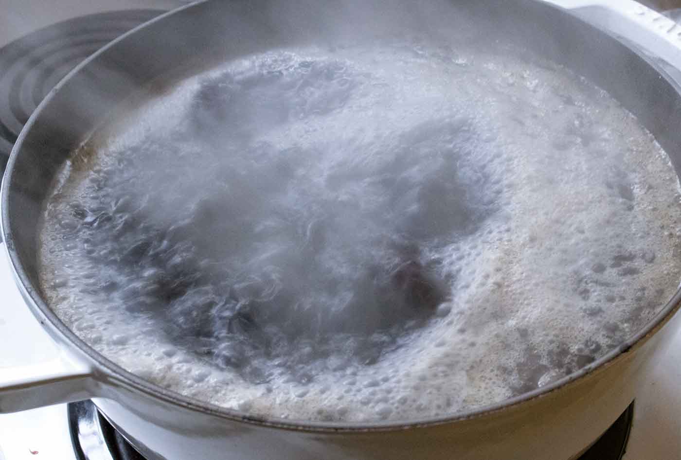 The beans and liquids settling down to a simmer to start their long cook.