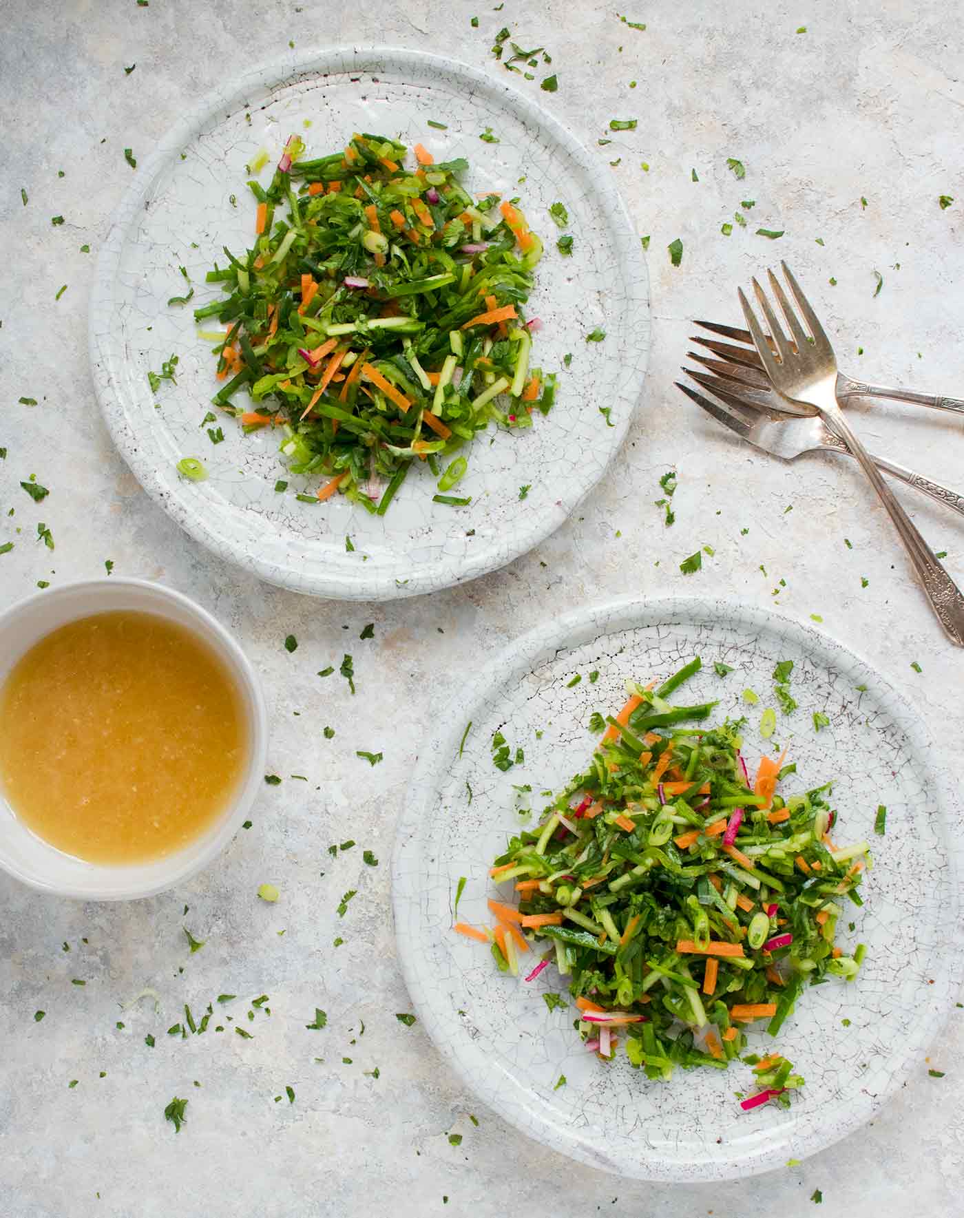 Two plates of cucumber slaw with Asian dressing on the side