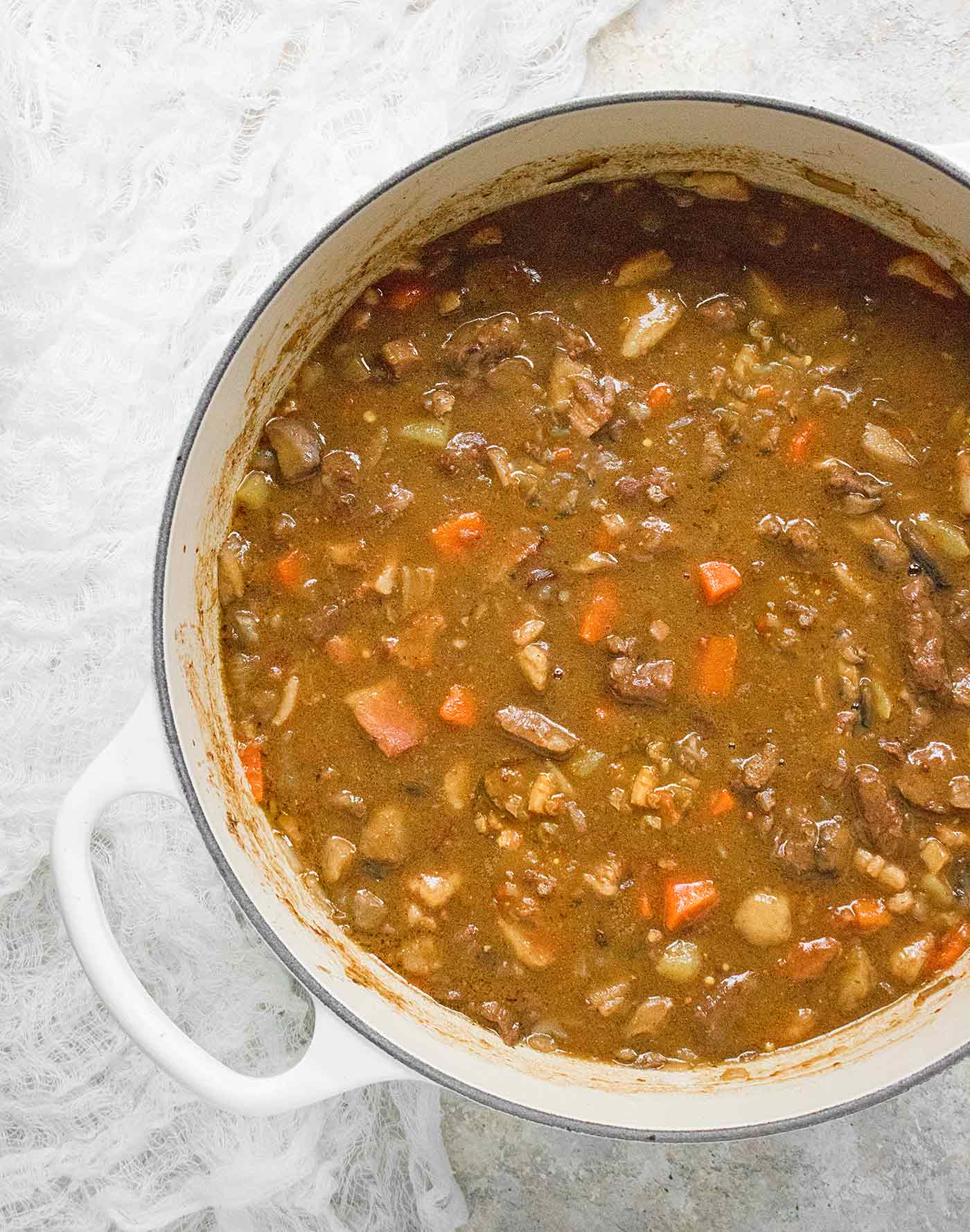 Dijon Beef Stew in a large white Dutch oven