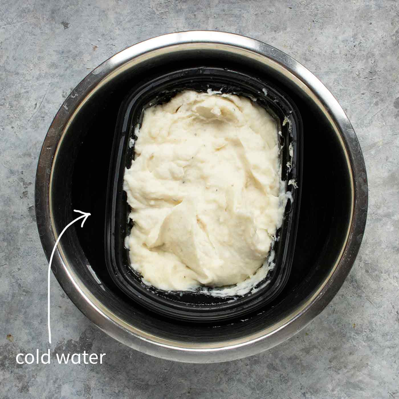 Cooked mashed potatoes cooling in a bowl.