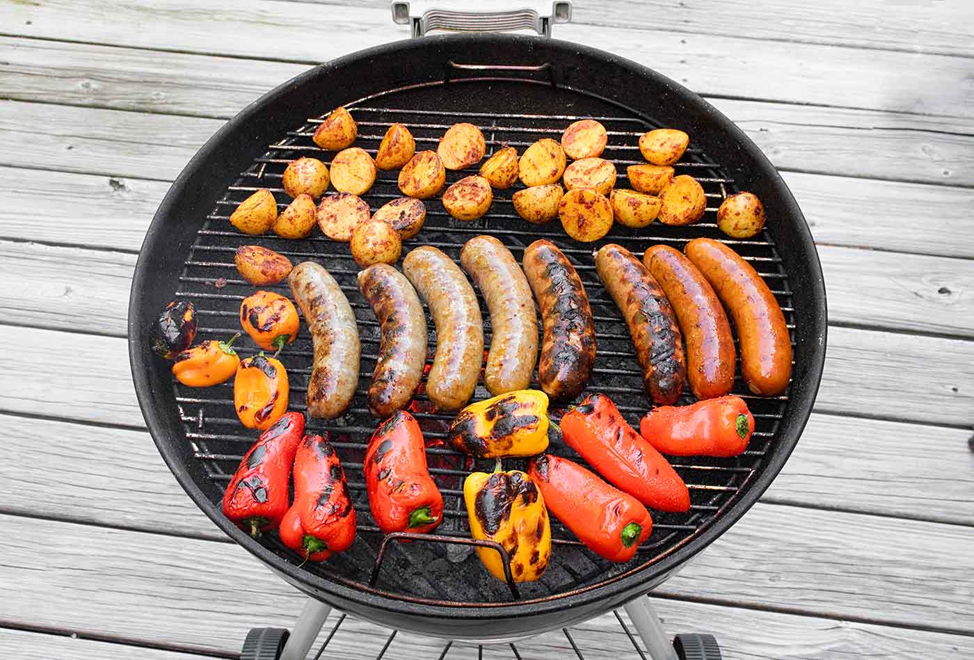 Sausages, peppers, and baby potatoes on the grill