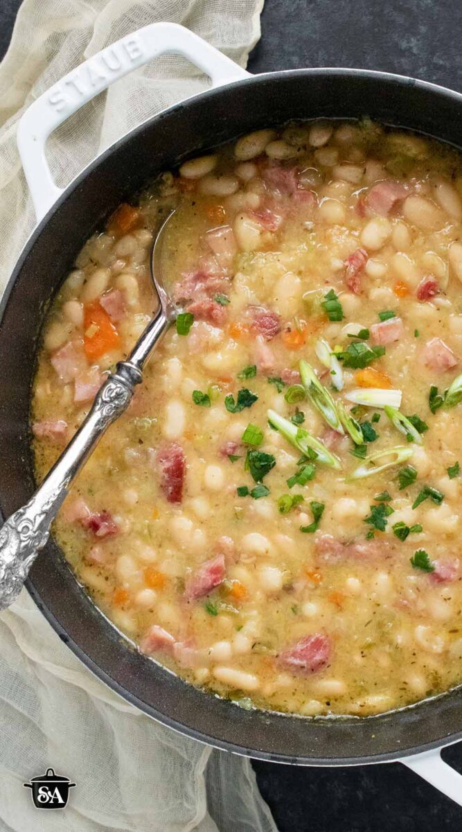 Overhead view of Ham and Bean Soup in a large white soup pot.