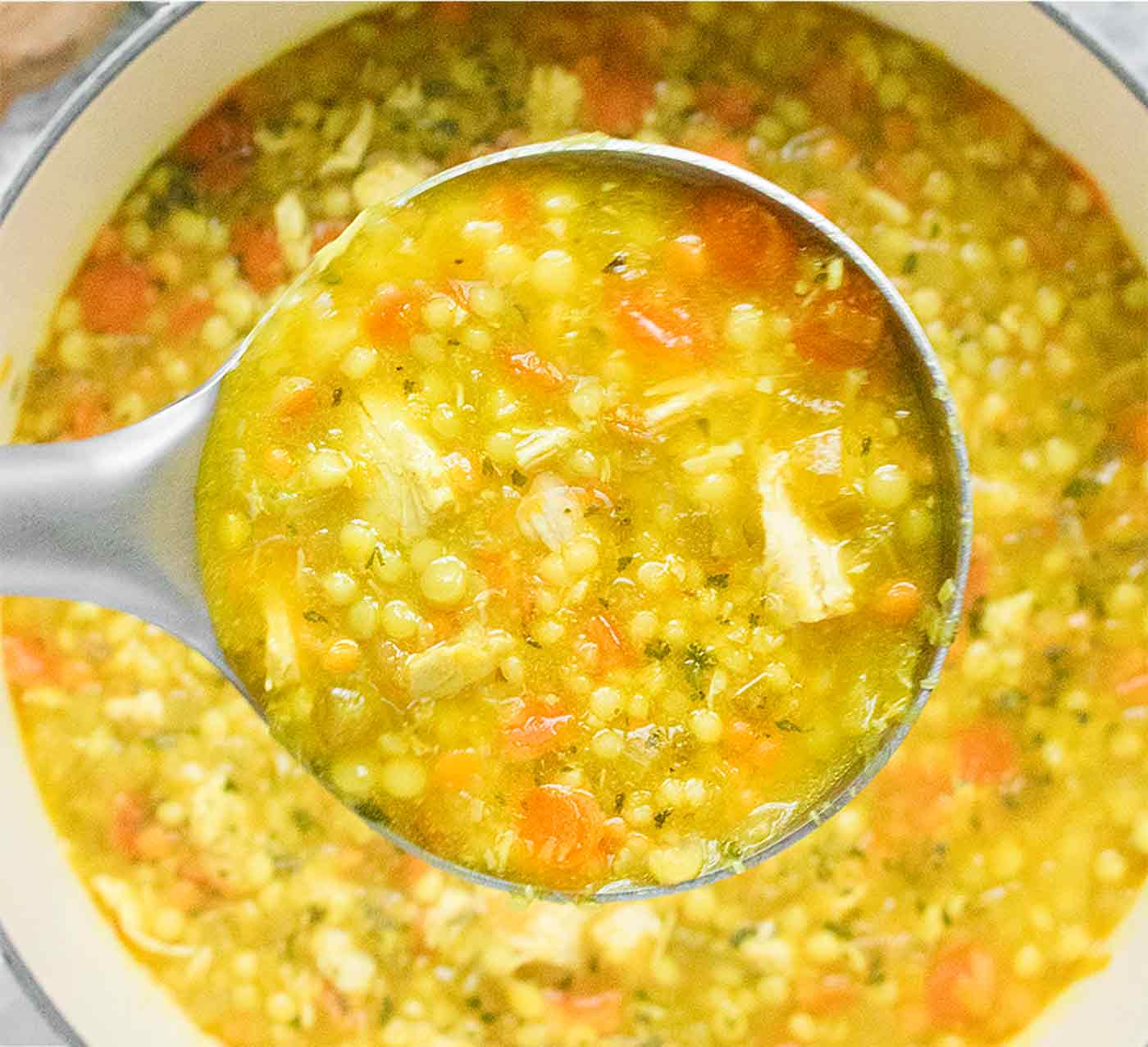 How to Make Great Soup - close up of chicken soup in a ladle.