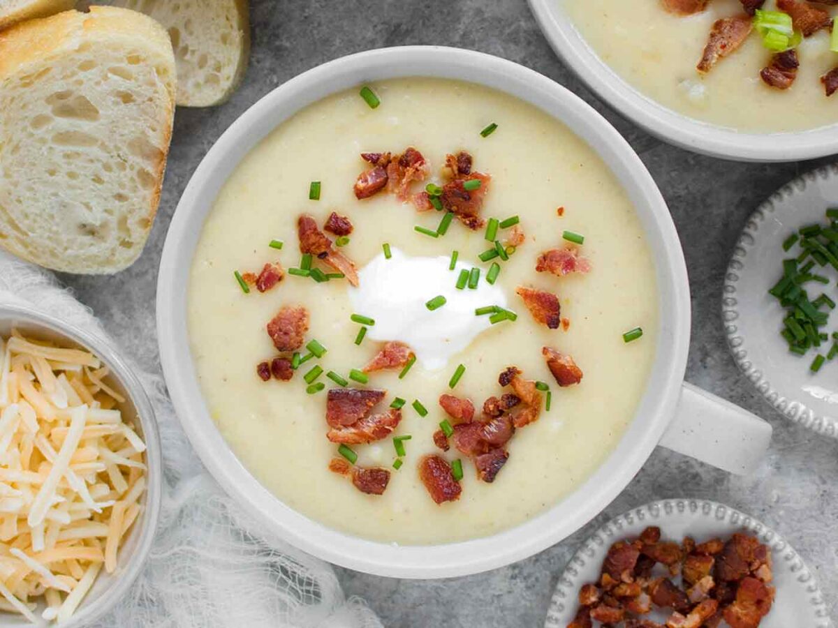 Overhead view of Instant Pot Loaded Potato Soup with toppings in a light gray bowl.