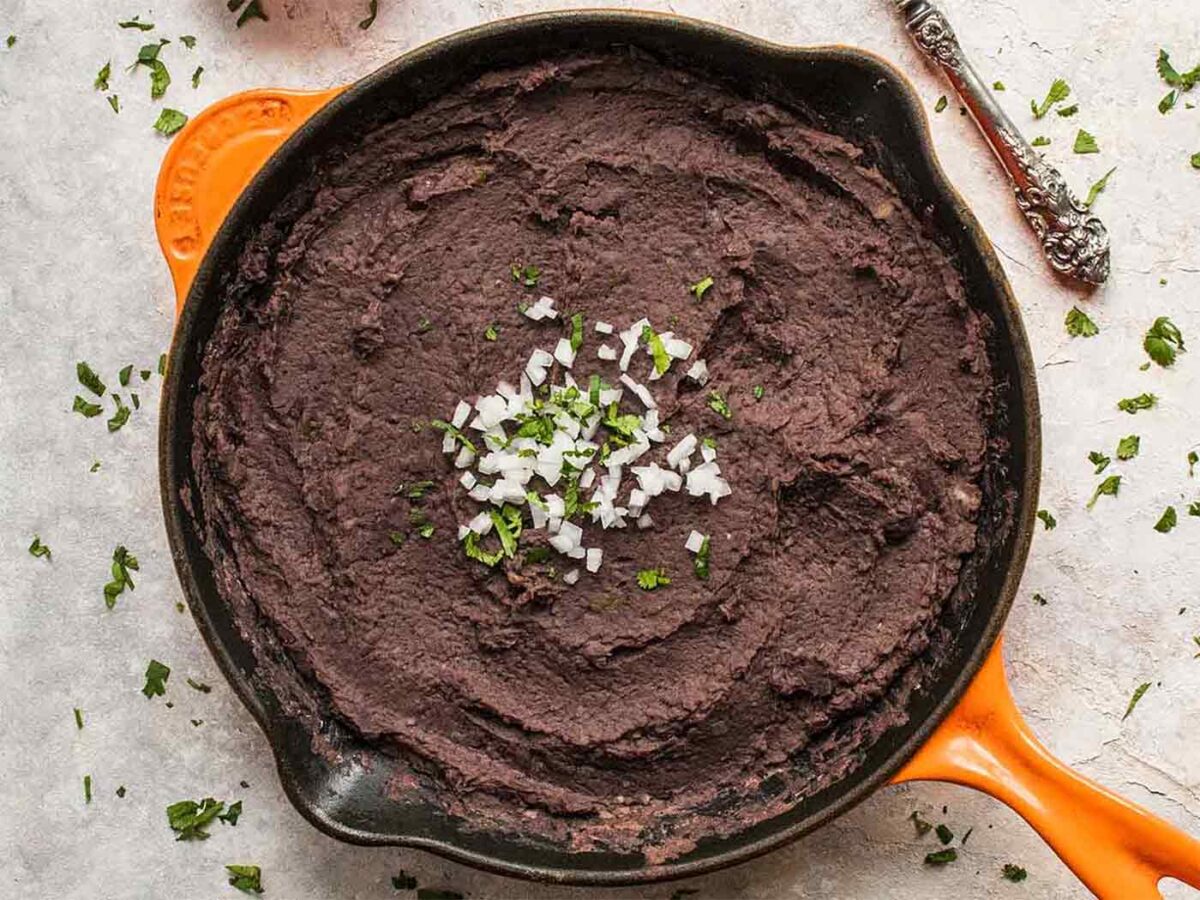 Refried black beans, made in the Instant Pot, finishing up in a cast iron skillet.