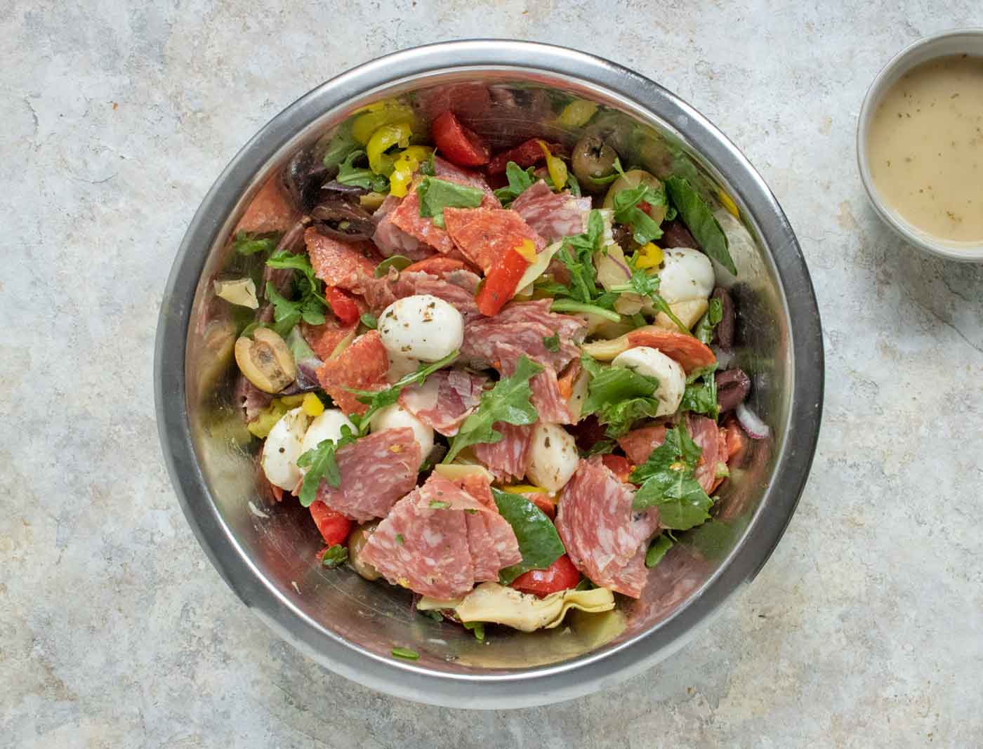 Overhead view of salad ingredients in a mixing bowl.