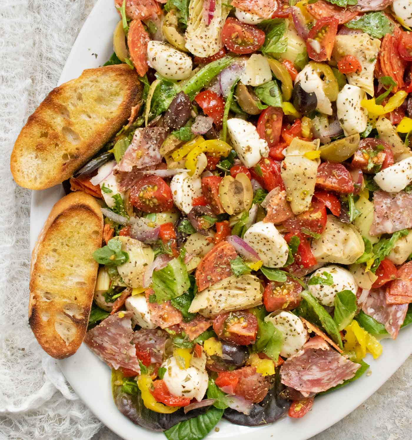 Overhead view of Italian Antipasto Salad on a white platter.