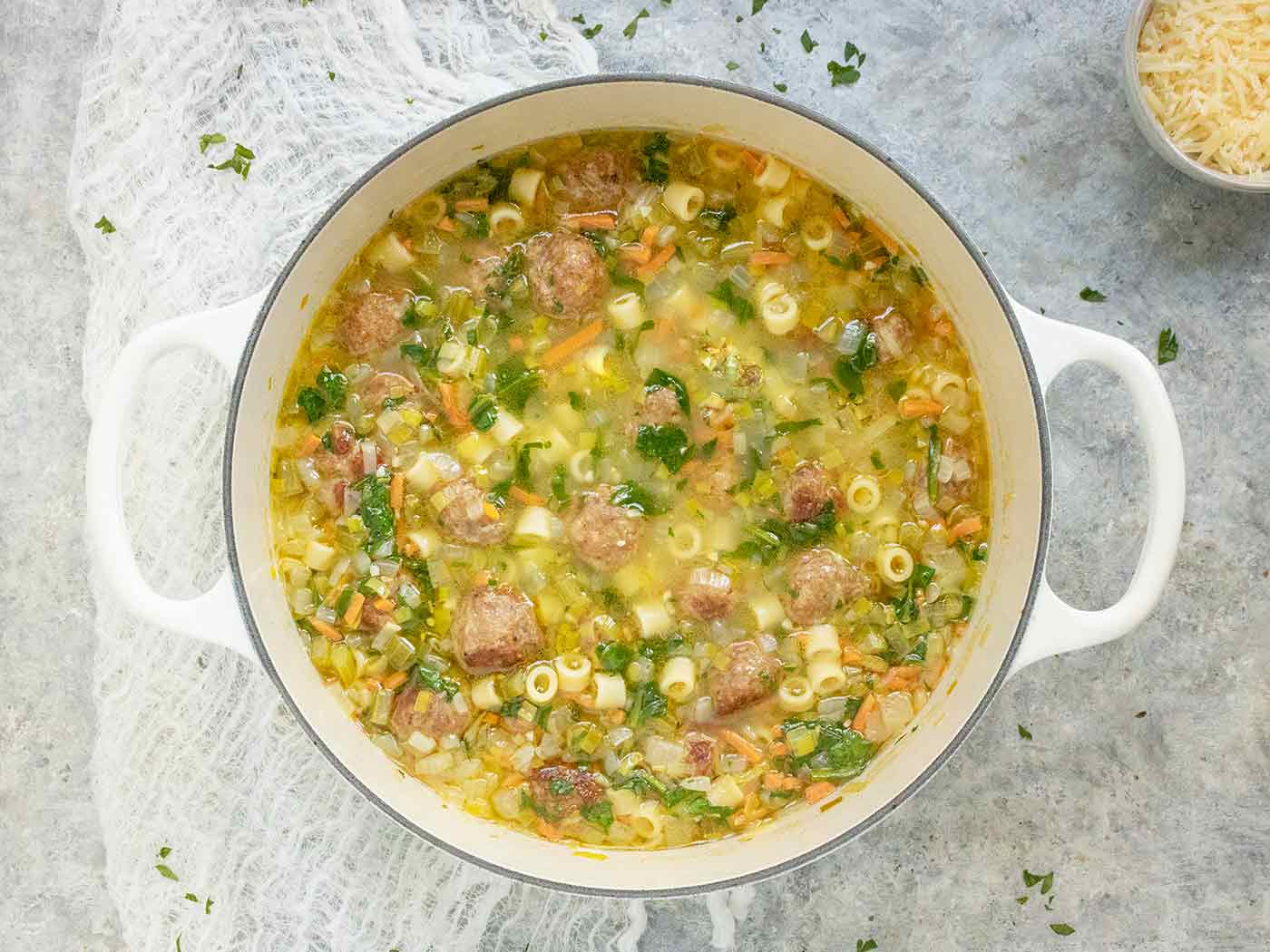 Italian Wedding Soup in a white Dutch Oven.