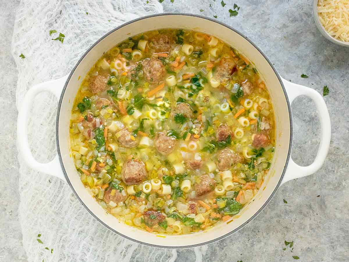 Italian Wedding Soup in a white Dutch oven.