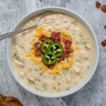 Jalapeno Popper Chicken Soup in a bowl with a spoon.