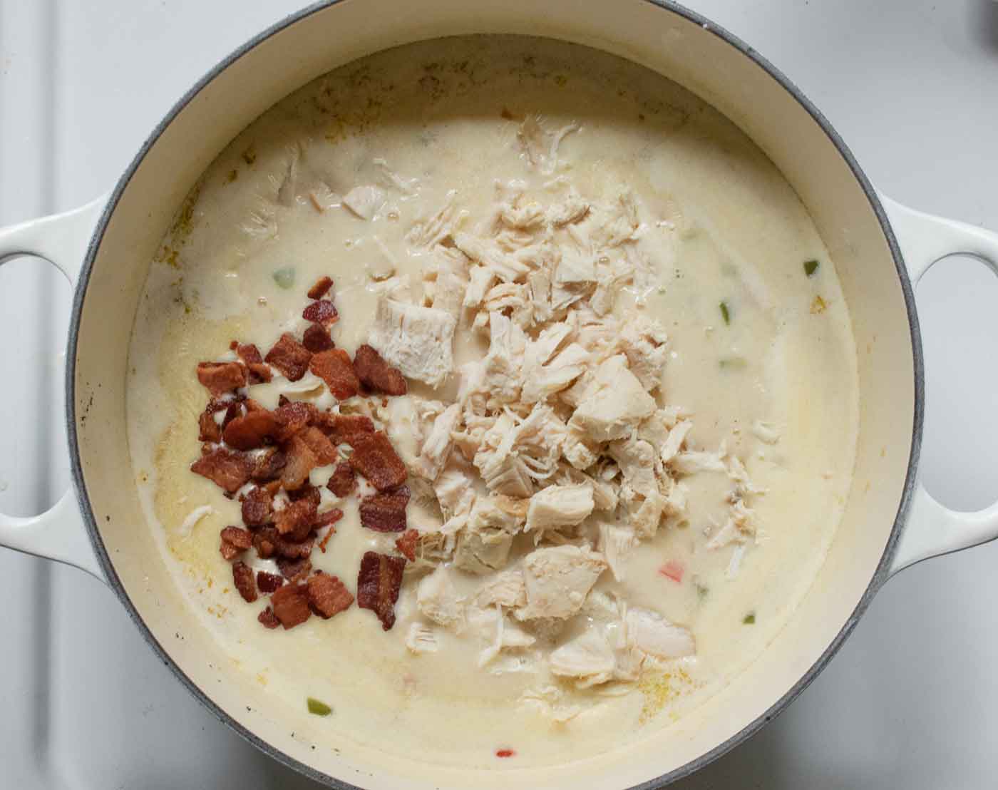 Finish the Jalapeno Popper Chicken Soup by stirring in the cooked chicken and bacon.