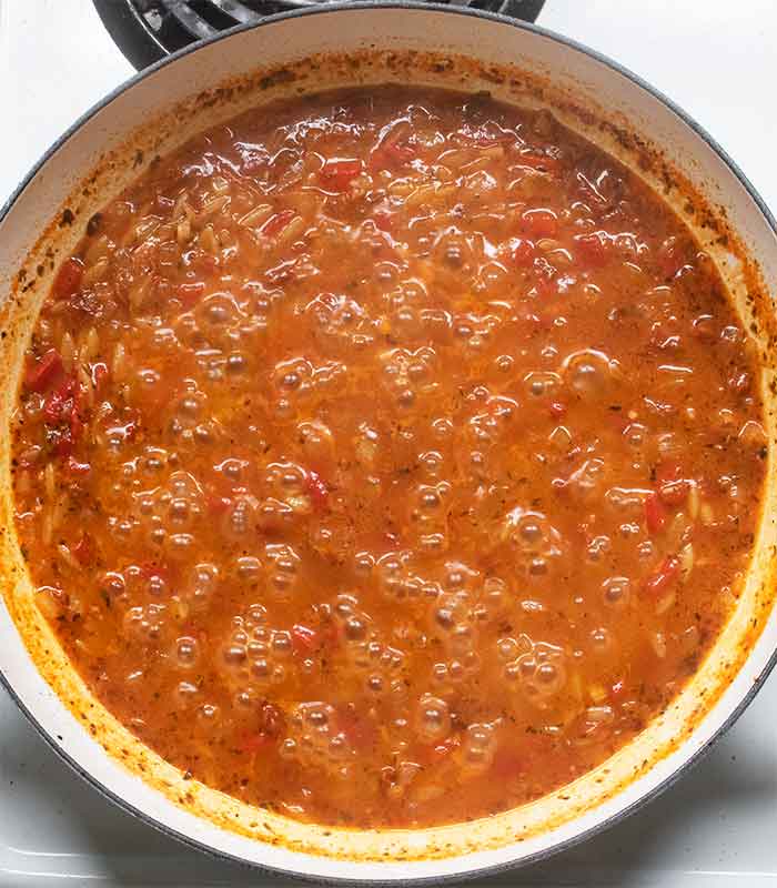 Orzo cooking in the liquids to create the base for the sauce.