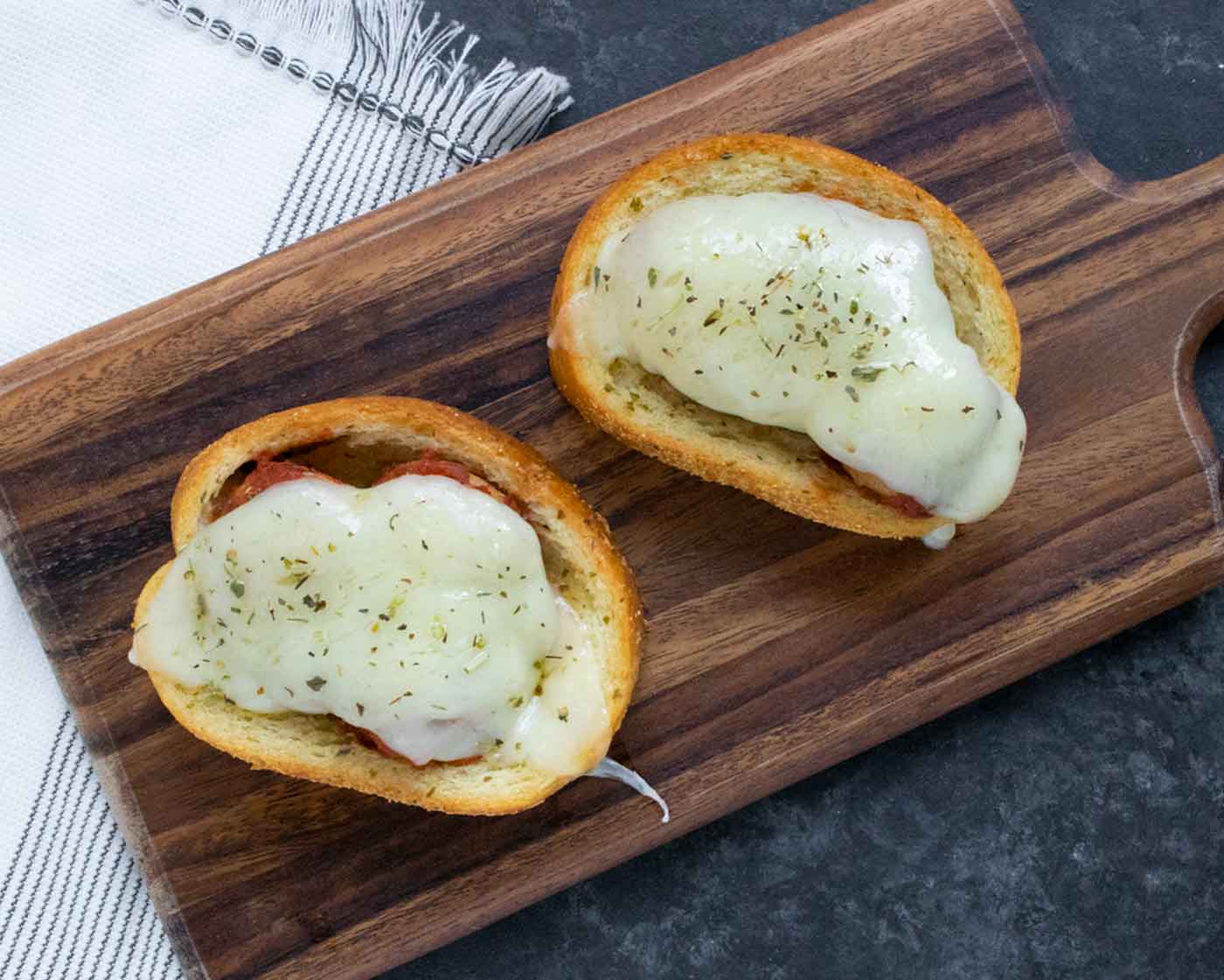 Overhead view of two Meatballs on Texas Toast on a cutting board.